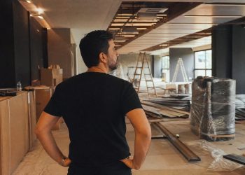 Lojista reformando o ponto comercial alugado, com obras de pintura e instalações, refletindo sobre quem paga as benfeitorias na locação em Belo Horizonte