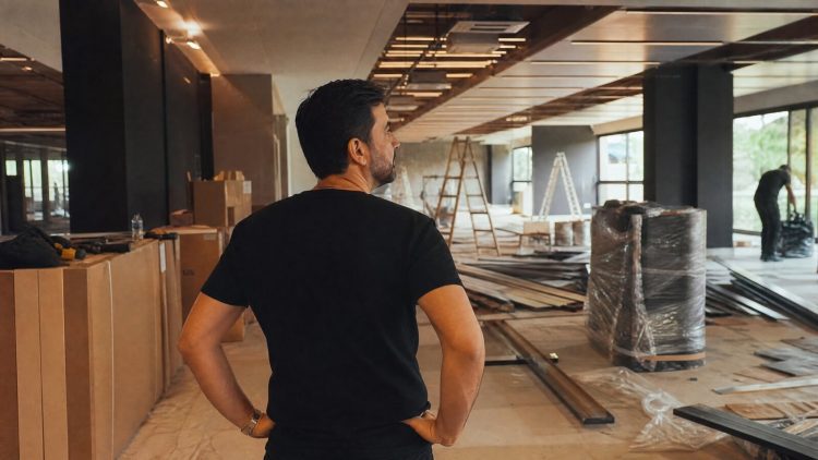 Lojista reformando o ponto comercial alugado, com obras de pintura e instalações, refletindo sobre quem paga as benfeitorias na locação em Belo Horizonte