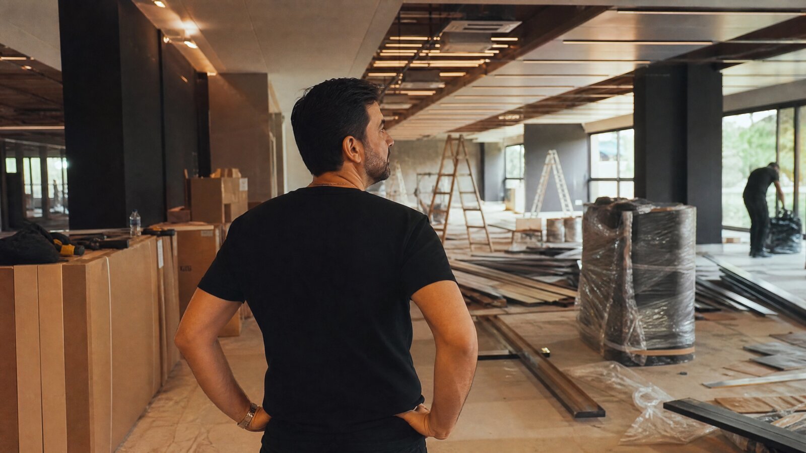 Lojista reformando o ponto comercial alugado, com obras de pintura e instalações, refletindo sobre quem paga as benfeitorias na locação em Belo Horizonte